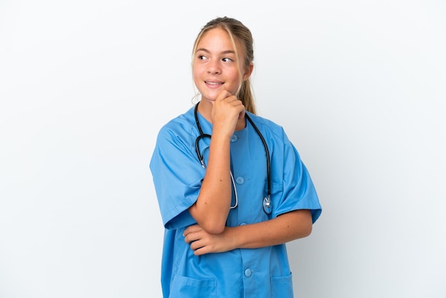 Little caucasian girl disguised as surgeon isolated on white background looking to the side