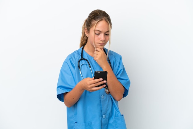 Little caucasian girl disguised as surgeon isolated on white background thinking and sending a message