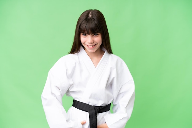 Little Caucasian girl doing karate over isolated background laughing