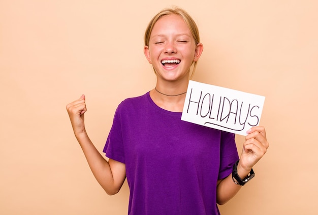 Little caucasian girl holding holidays placard isolated on beige background