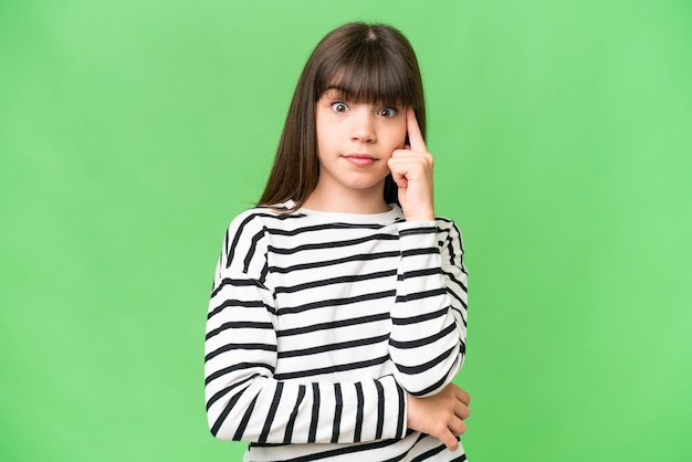 Little caucasian girl over isolated background thinking an idea