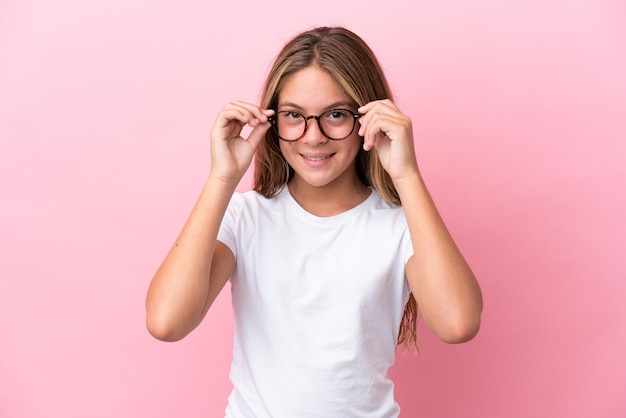 Little caucasian girl isolated on pink background With glasses with happy expression