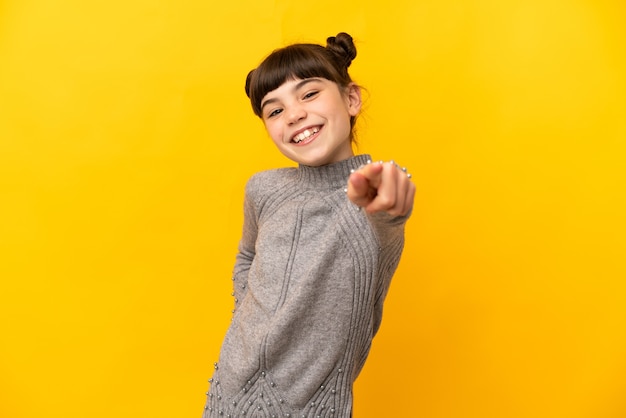 Little caucasian girl isolated pointing front with happy expression