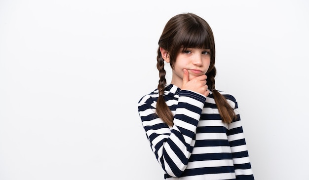 Little caucasian girl isolated on white background having doubts