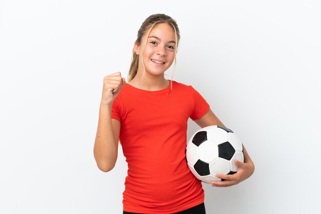 Little caucasian girl isolated on white background with soccer ball celebrating a victory