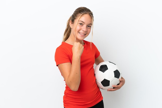 Little caucasian girl isolated on white background with soccer ball celebrating a victory