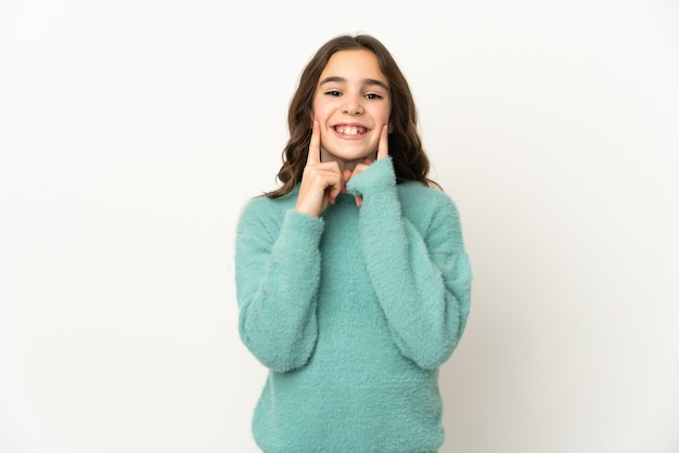 Little caucasian girl isolated on white wall smiling with a happy and pleasant expression