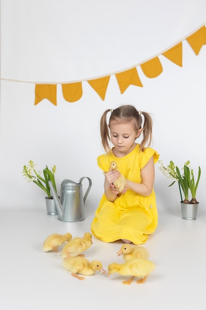 Little caucasian girl preschool age holding a cute duckling in the hands