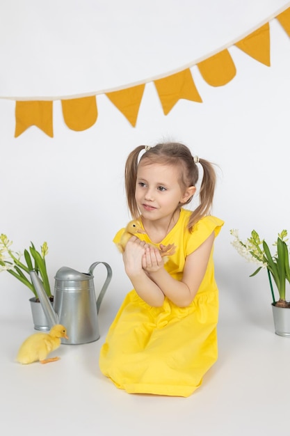 Little caucasian girl preschool age holding a cute duckling in the hands