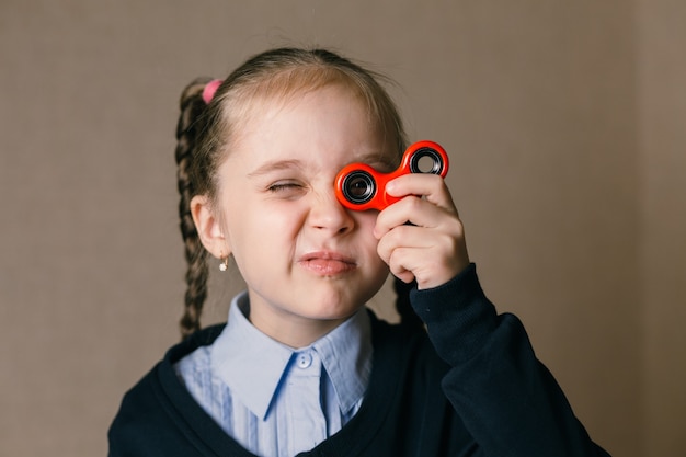 Little caucasian girl with Fidget Spinner held up to his eyes