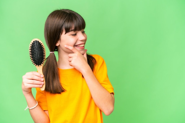 Photo little caucasian girl with hair comb over isolated background thinking an idea and looking side