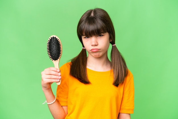 Little caucasian girl with hair comb over isolated background with sad expression