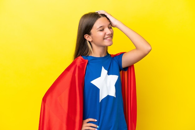 Little caucasian superhero girl isolated on yellow background has realized something and intending the solution