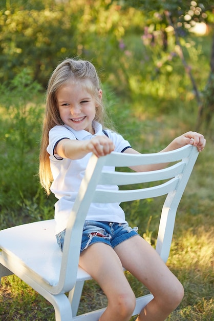 Little charming girl in the summer garden