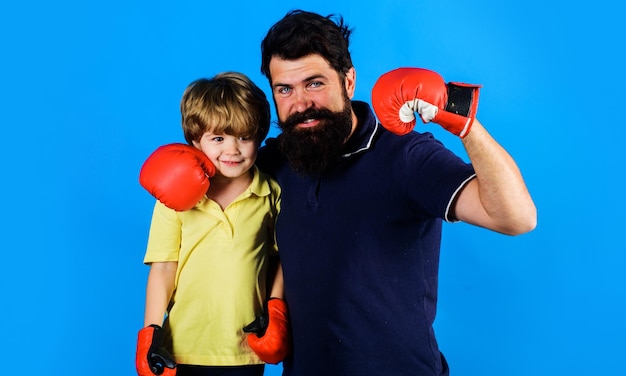 Little child boy in boxing gloves with coach trainer with kid boxer stand together sport lifestyle