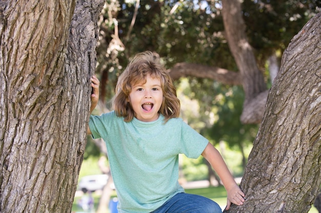 Little child boy trying to climb a tree kids climbing a tree happy boy enjoying summer day in a gard