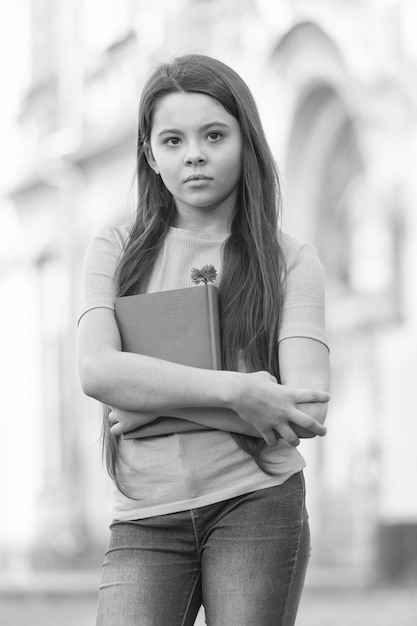 Little child girl back to school hold textbook knowldge day concept