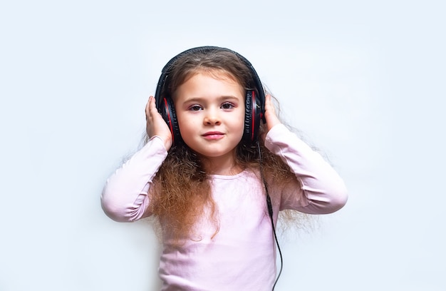 Little child in headphones isolated on white