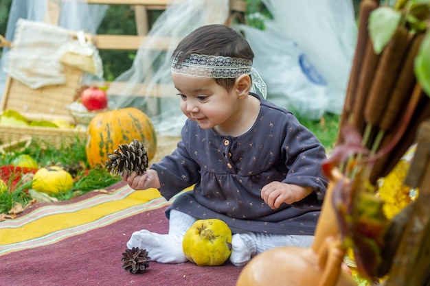 the little child playing in the park with fruits little girl in the autumn park