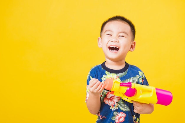 Little children boy so happy in Songkran festival day holding water gun