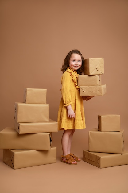 Little curly girl with big stack of gifts for the holiday