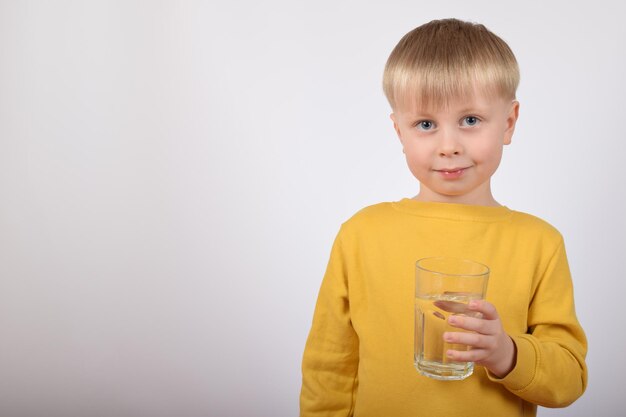 little cute baby boy holding a glass of water