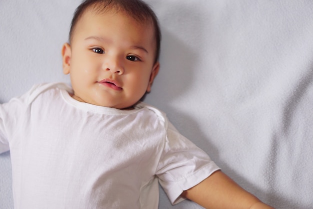 Little cute baby lying blue mattress and looking at camera The concept of empathyadorable