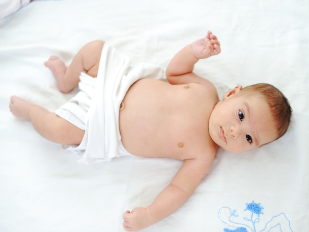 Little cute couple months old baby in his bed at home