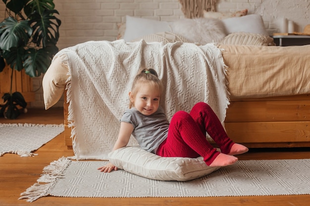 Little cute girl have fun near the bed.