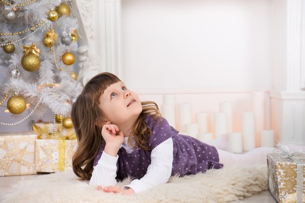 Little cute girl near the Christmas tree