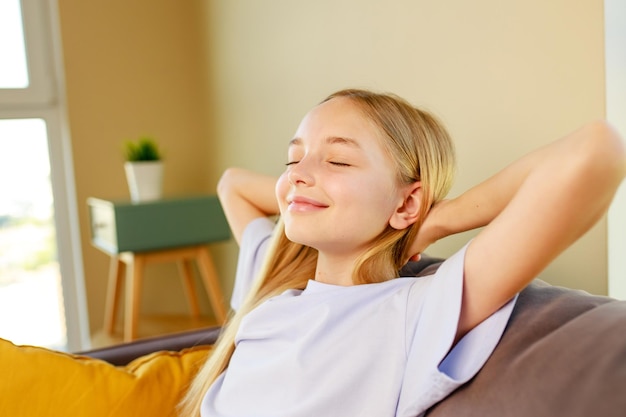 Little cute girl sleeping on sofa after study in school daytime