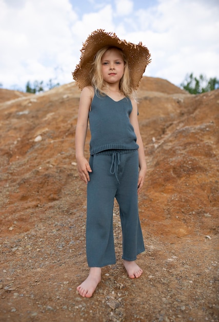 Little cute girl in stylish clothes in a nature scenery