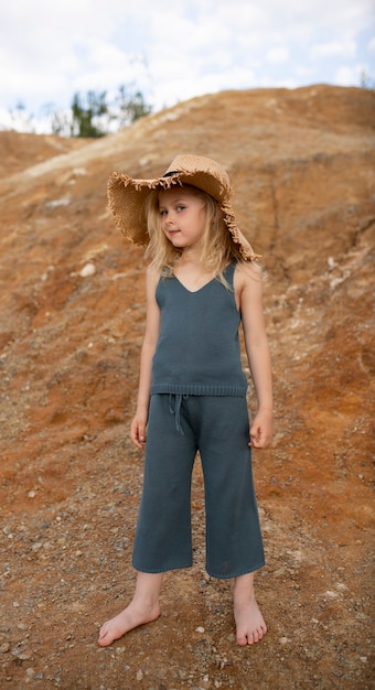 Little cute girl in stylish clothes in a nature scenery