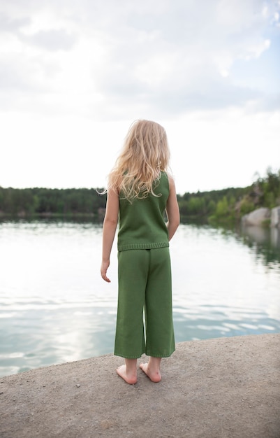 Little cute girl in stylish clothes in a nature scenery