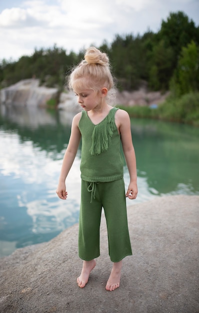 Little cute girl in stylish clothes in a nature scenery