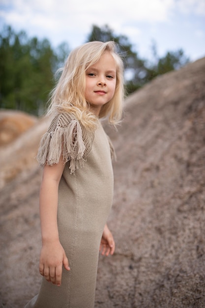 Little cute girl in stylish clothes in a nature scenery