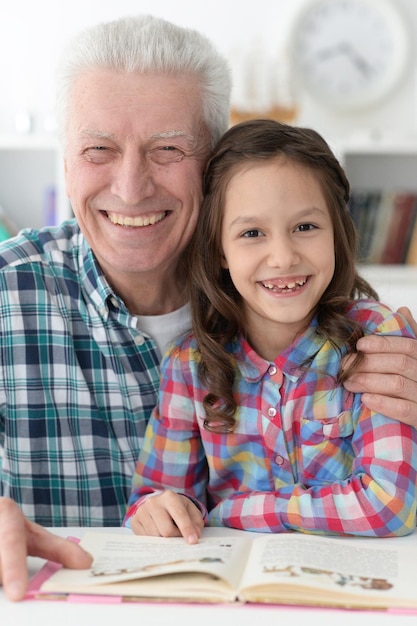 Little cute girl with grandfather reading book