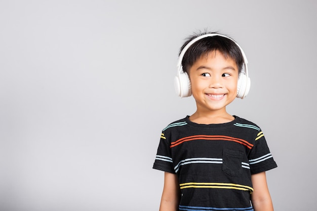 Little cute kid boy 5 years old listen music in wireless headphones