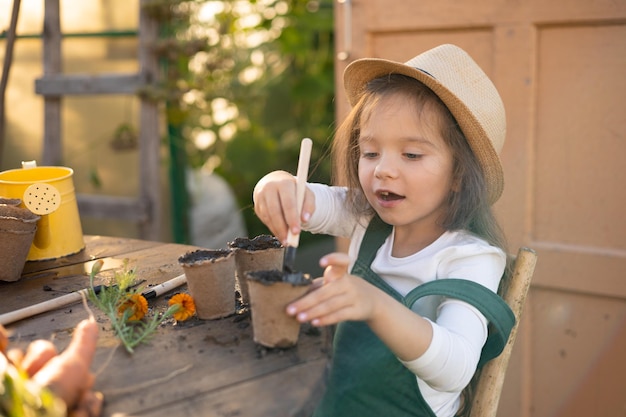 A little cute longhaired farmer girl is engaged in planting plants Village vegetable garden gardening Ecology