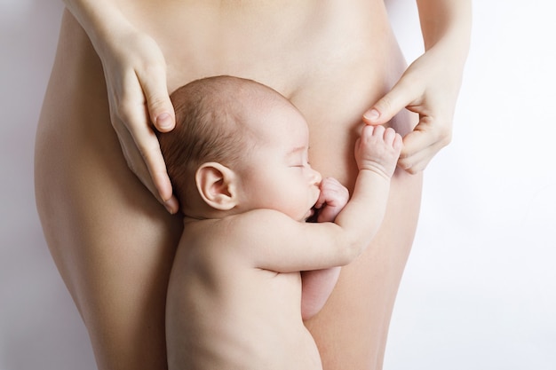 Little and cute newborn baby lying on the mother belly