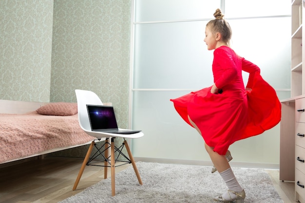 Little dancer in a red latin dance dress dances at home learns to dance remotely Dance lessons at home Dance lessons online