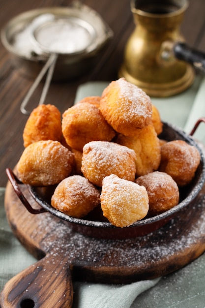 Little Donuts. Homemade curd fried cookies in deep fat and sprinkled with icing sugar in a vintage plate