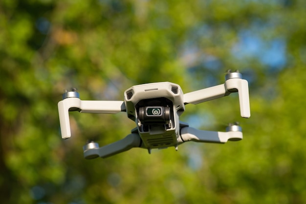 Little drone with camera in the air with trees at the 