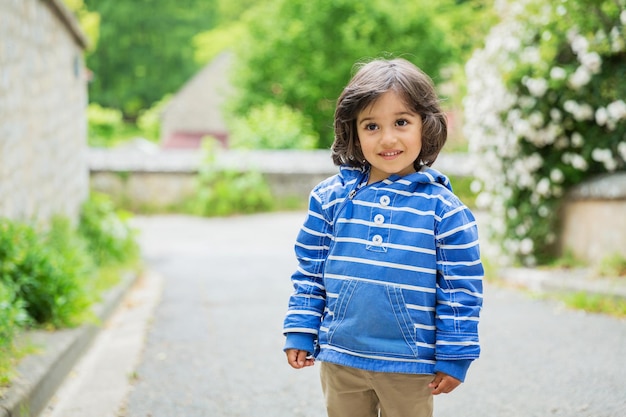 Little eastern handsome baby boy staying outdoor in old town in France