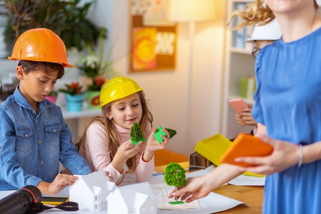 Little engineers. Future little engineers feeling joyful while studying house modeling at the primary school