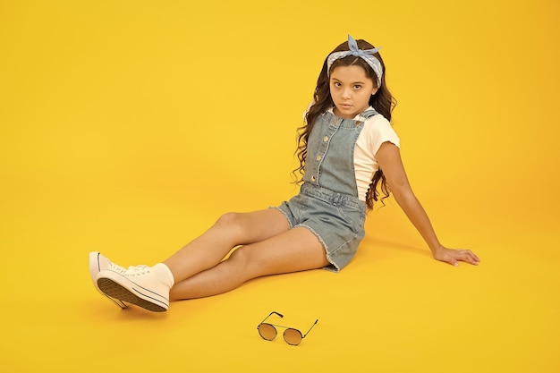 Little fashionista Carefree happy childhood Modern clothing for teen Cute small kid fashion girl Fashion accessories Summer outfit concept Girl long curly hair sit relaxing Fashion trend