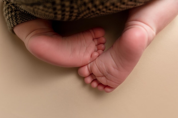 little feet a newborn baby in a white scarf. soft focus