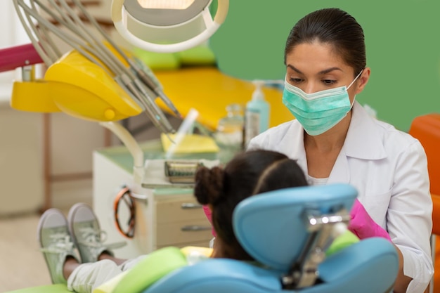 Little female patient sitting in a dentists chair