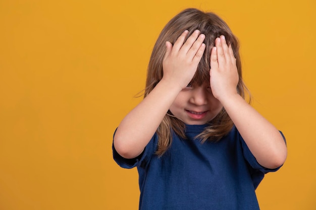 Little forgotten child girl covers her face with her hands