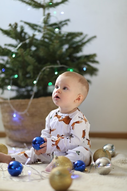 Little funny boy sitting near new year eve